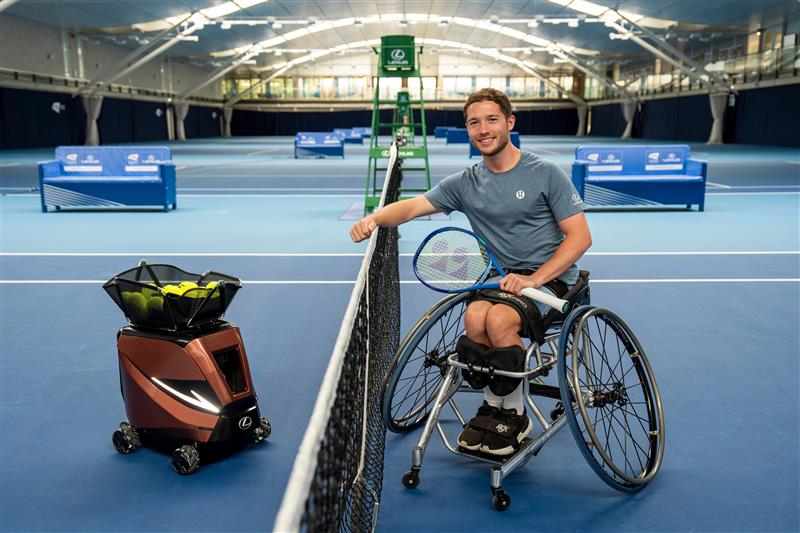 Alfie Hewett poses next to the brand new, Lexus 'Signature Shot' machine programmed to replicate his tennis serve.