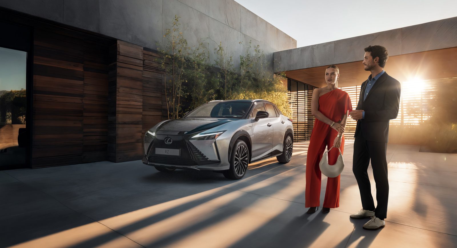 Lexus RZ with two people standing in front of car